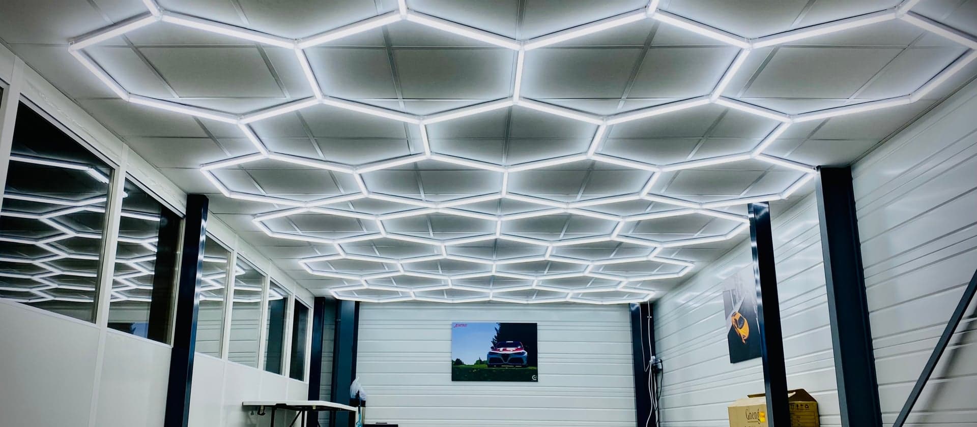Intérieur de l'atelier AWD Magny-Cours — showroom avec éclairage hexagonal LED