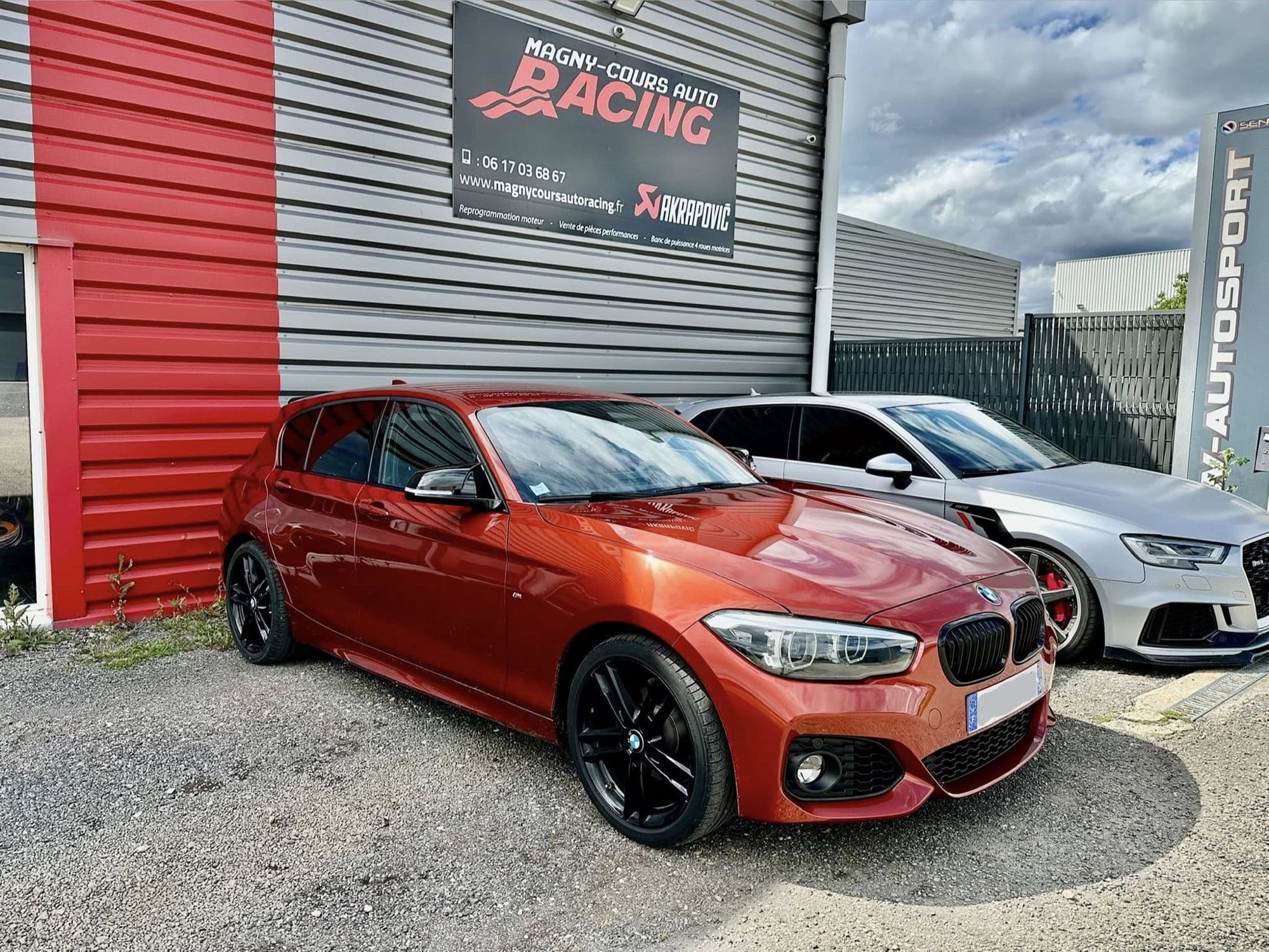 Devanture de l'atelier AWD Magny-Cours à Saint-Parize-le-Châtel, avec une BMW Série 1 M Performance équipée d'une ligne Akrapovic